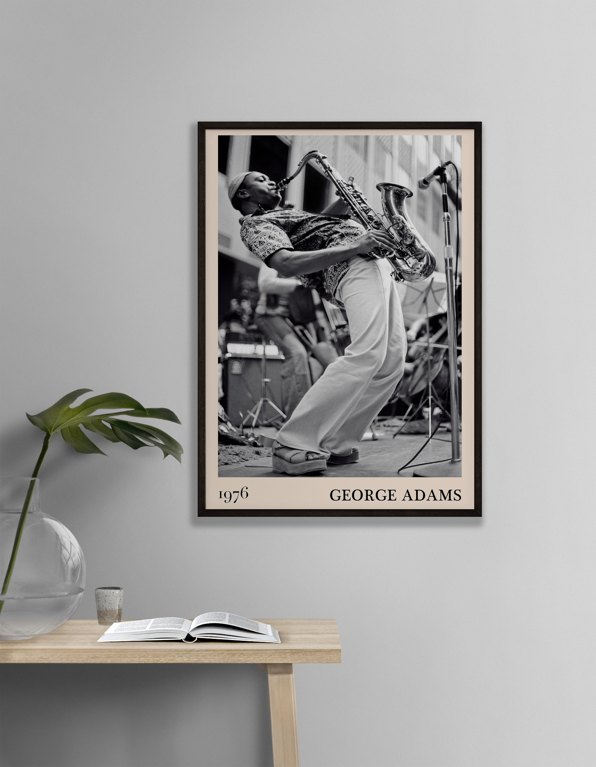 1976 photograph of George Adams taken by Thomas Marcello. Picture crafted into a cool black framed jazz print, with an off-white border. Poster is hanging on a off-white living room wall.