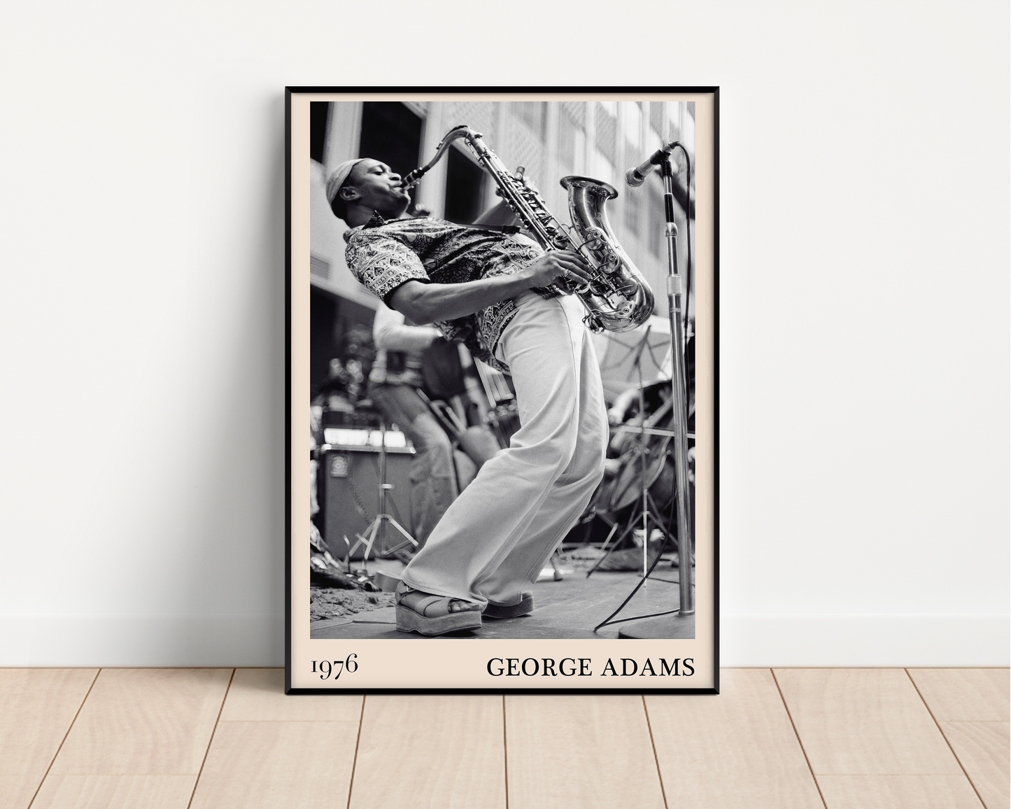 1976 photograph of George Adams taken by Thomas Marcello. Picture crafted into a black framed poster, with an off-white border. Poster is propped against a white wall