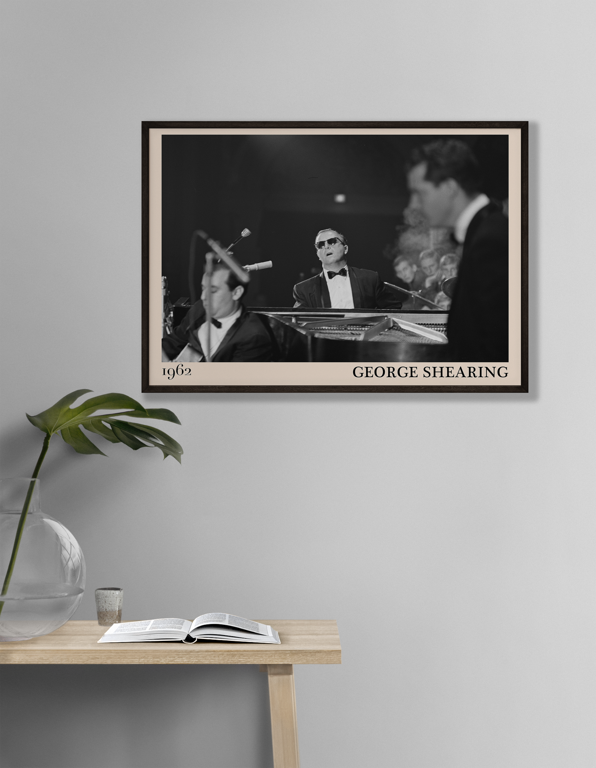 1962 picture of George Shearing playing piano. Picture crafted into a cool black framed jazz print, with an off-white border. Poster is hanging on a grey living room wall
