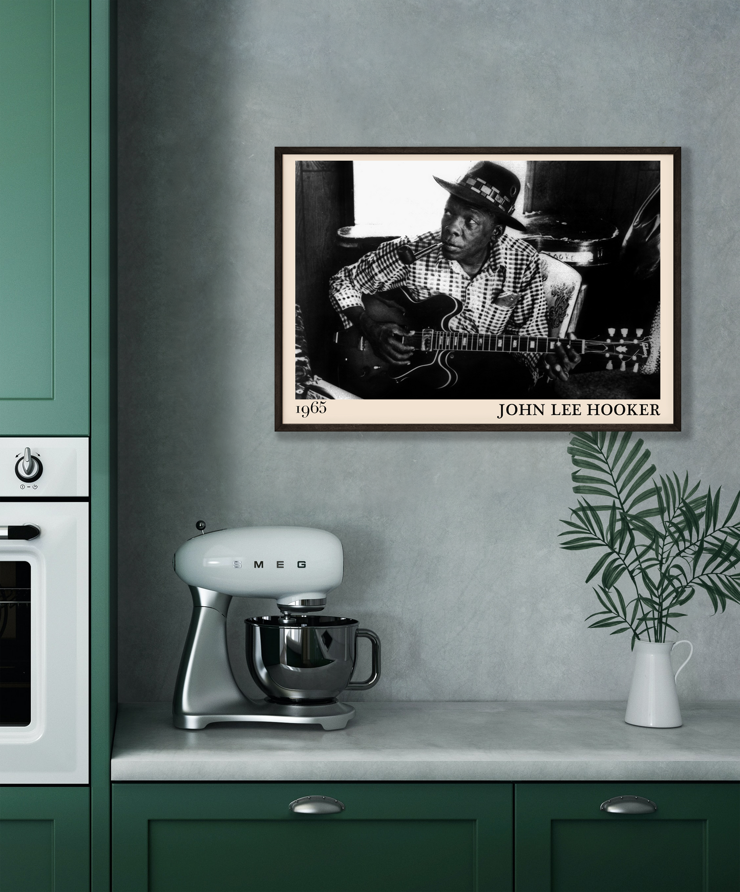 John Lee Hooker blues print hanging against a grey wall with surrounding dark green units in a kitchen