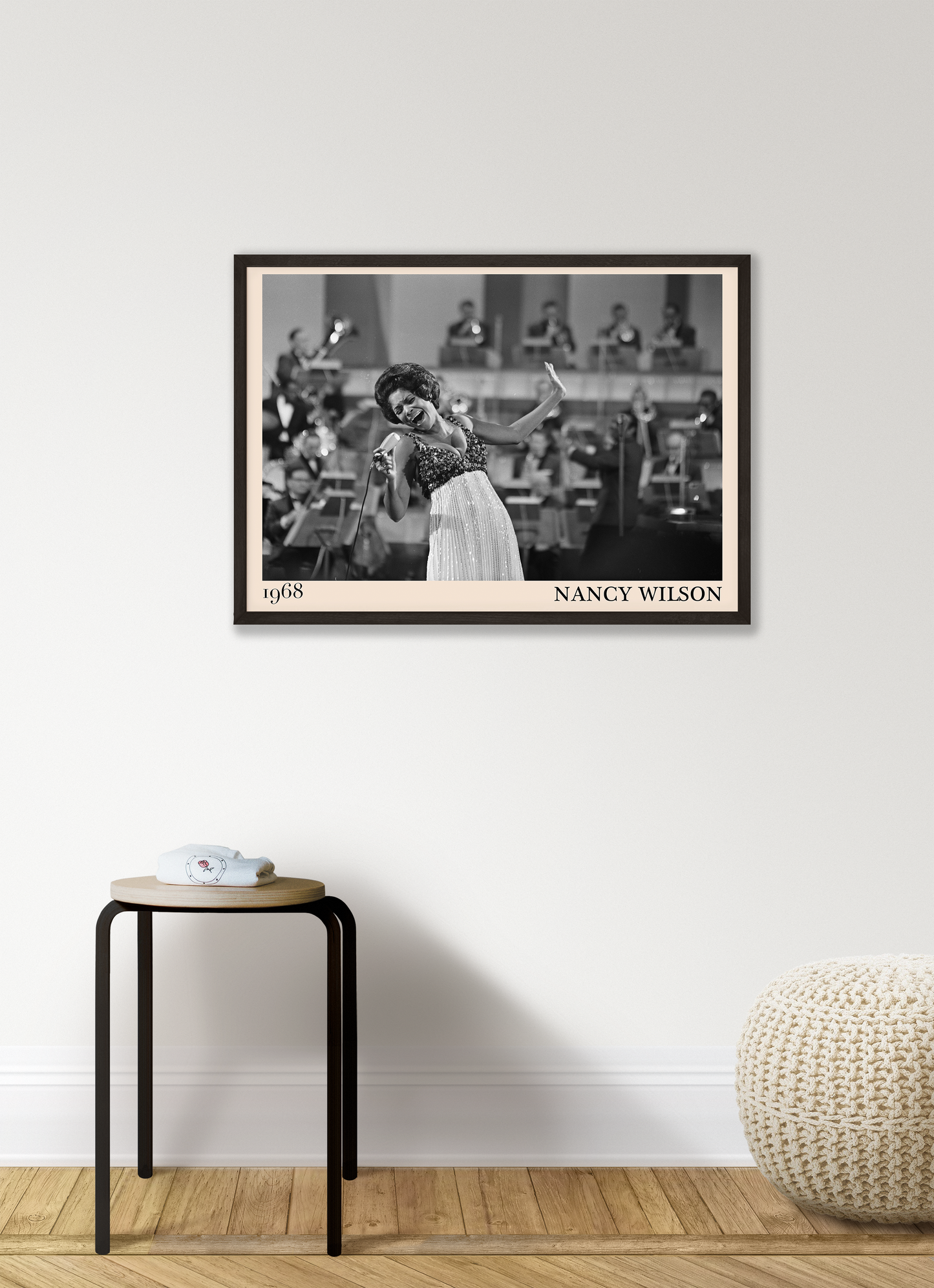 1968 picture of Nancy Wilson singing. Picture crafted into a retro black framed jazz print, with an off-white border. Poster is hanging on a grey living wall