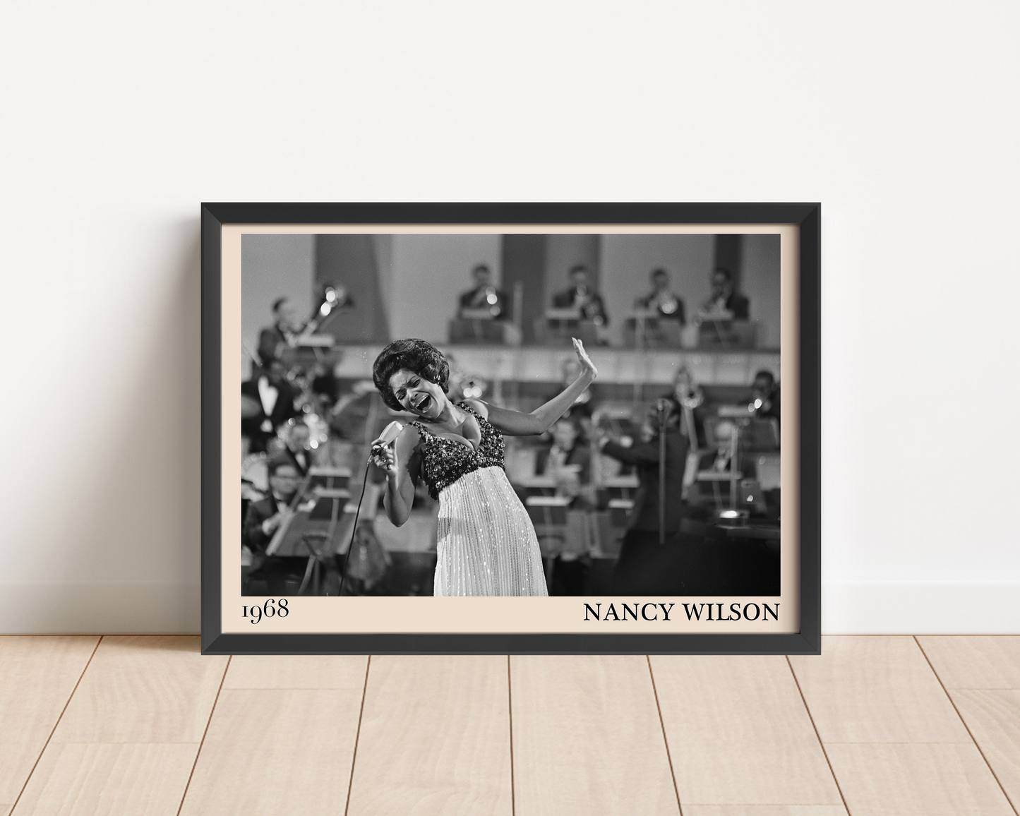 1968 picture of Nancy Wilson singing. Picture crafted into a black framed poster, with an off-white border. Poster is propped against a white wall
