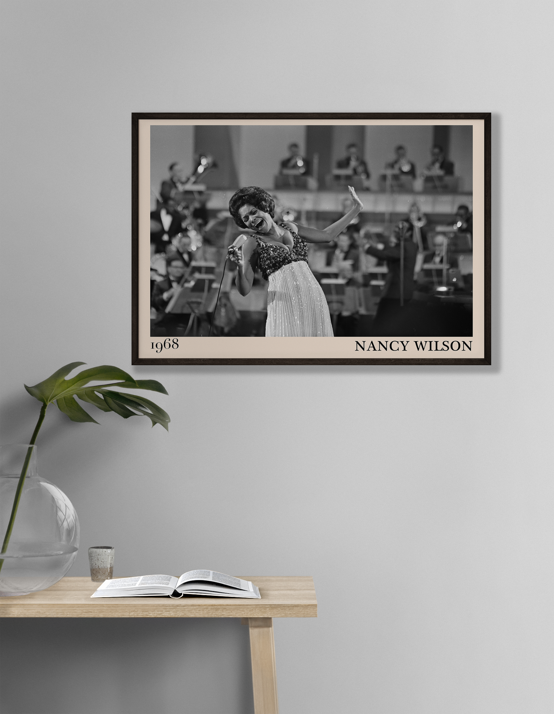 1968 picture of Nancy Wilson singing. Picture crafted into a cool black framed jazz print, with an off-white border. Poster is hanging on a grey living room wall