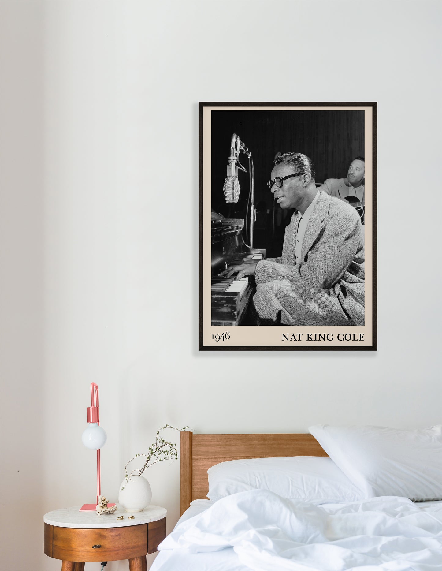 1946 picture of Nat King Cole playing a piano and singing. Picture crafted into a cool black framed jazz poster, with an off-white border. Poster is hanging on a white bedroom wall