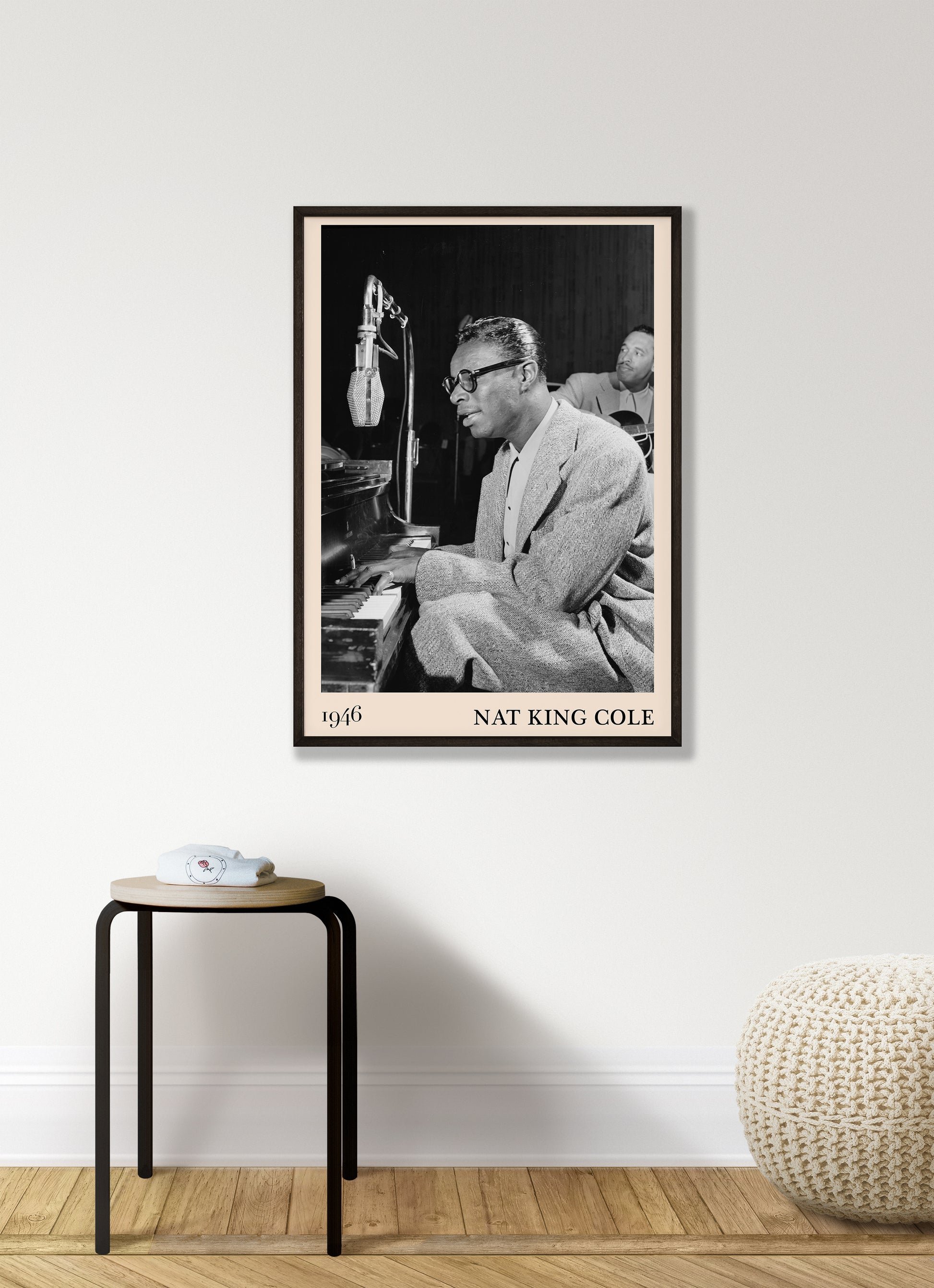 1946 picture of Nat King Cole playing a piano and singing. Picture crafted into a vintage black framed jazz print, with an off-white border. Poster is hanging on a white living room wall