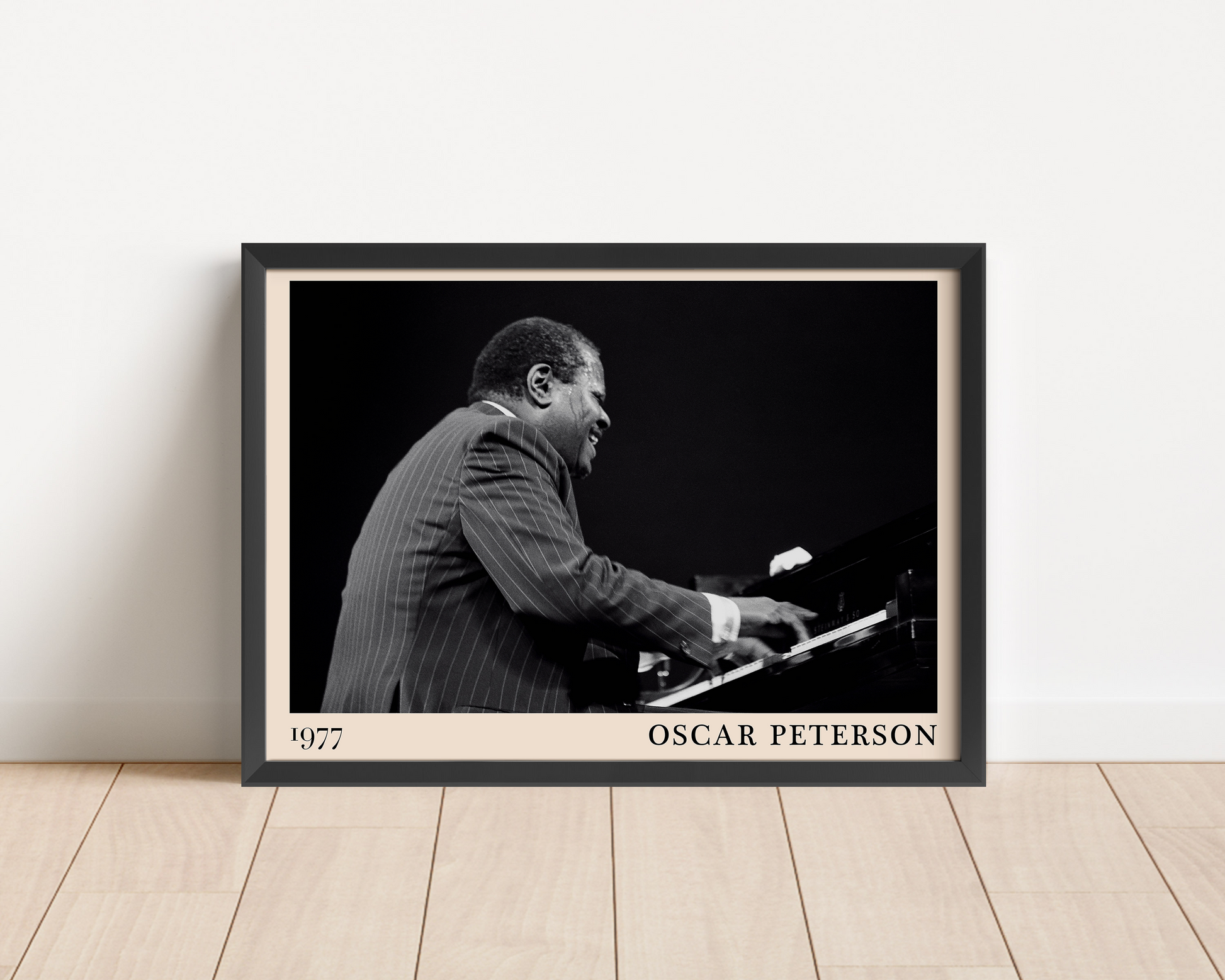 1977 photograph of Oscar Peterson taken by Thomas Marcello. Picture crafted into a black framed poster, with an off-white border. Poster is propped against a white wall