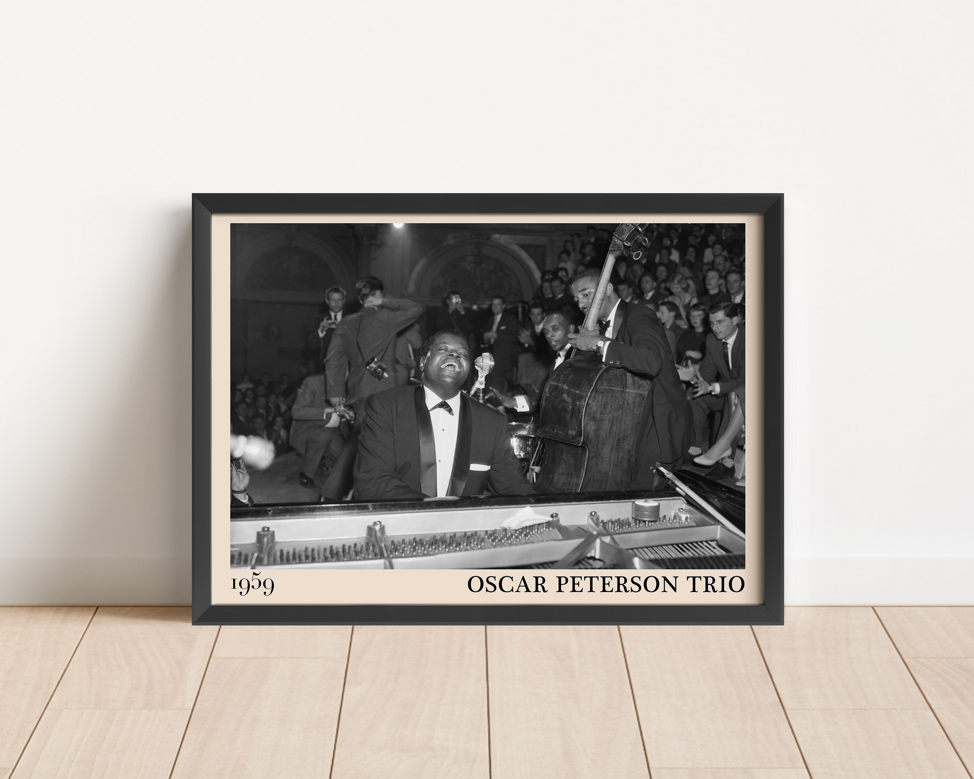 1959 picture of the Oscar Peterson Trio. Picture crafted into a black framed poster, with an off-white border. Poster is propped against a white wall