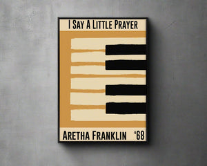 Framed  yellow jazz poster featuring a piano design and Aretha Franklin's 1968 song 'I Say a Little Prayer'. Vintage music decor, classic soul art, perfect for jazz and soul enthusiasts and Aretha Franklin fans