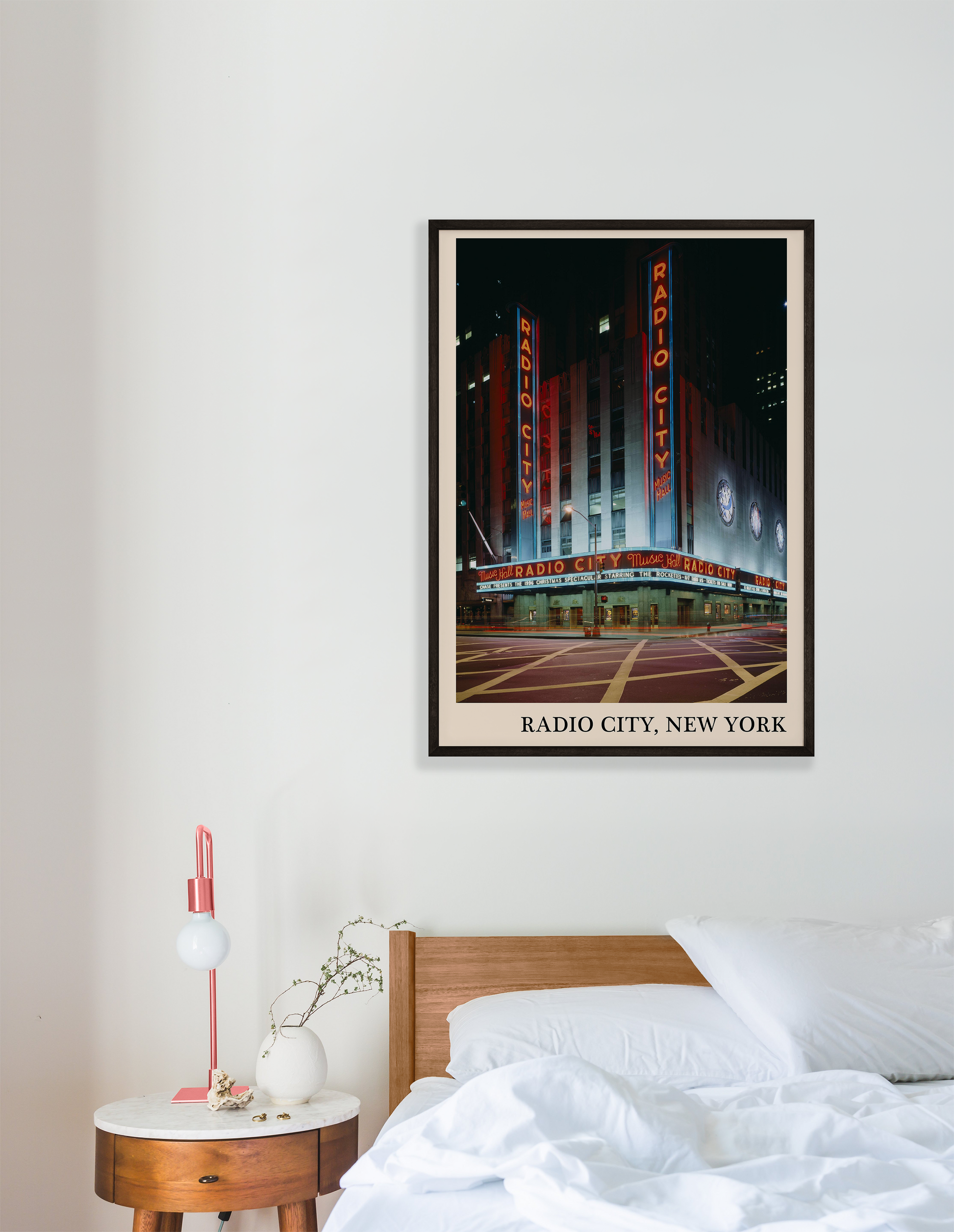 Iconic photo of Radio City in New York captured in a retro black framed jazz print, hanging on a white bedroom wall