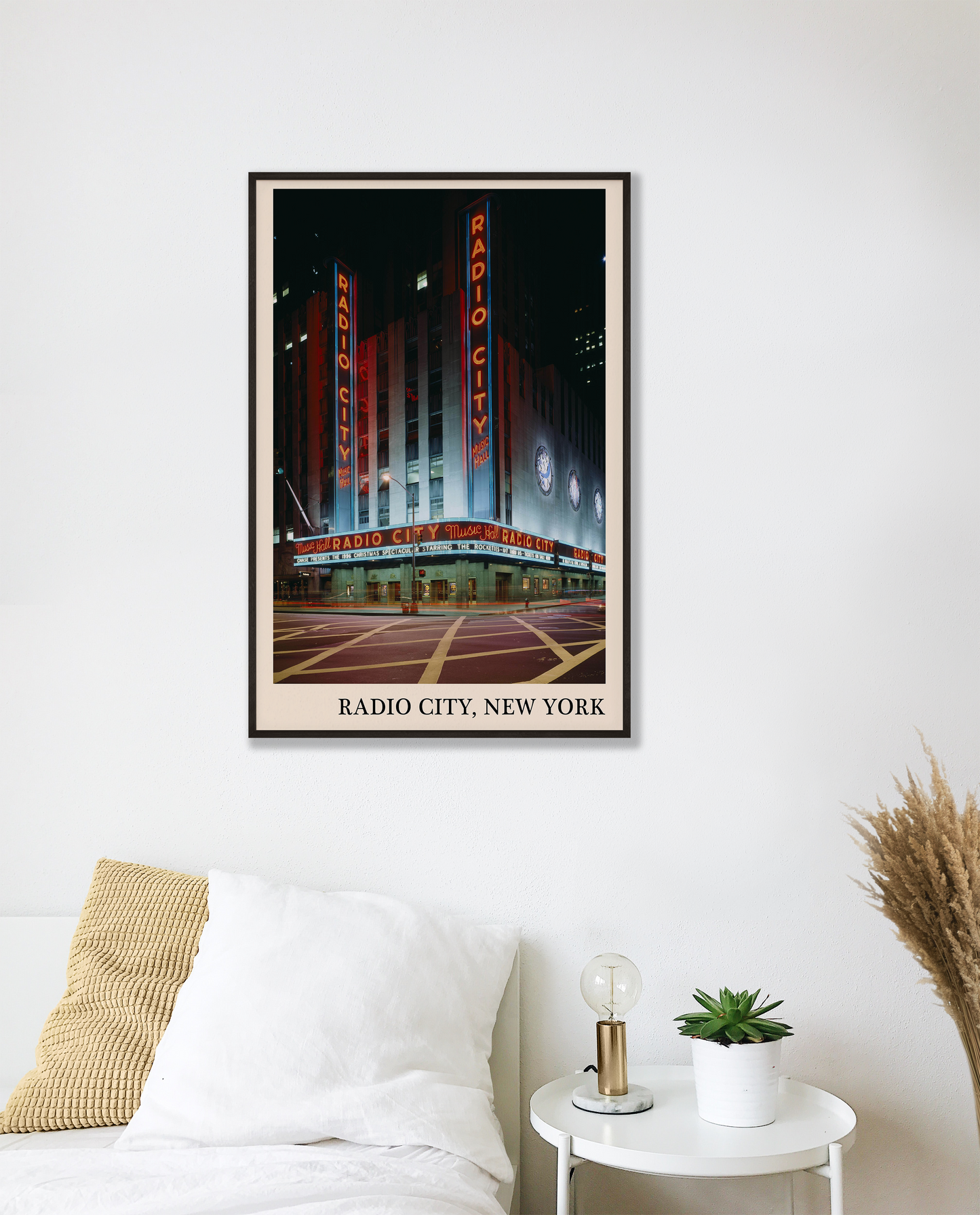 Iconic photo of Radio City in New York captured in a retro black framed music print, hanging on a white bedroom wall