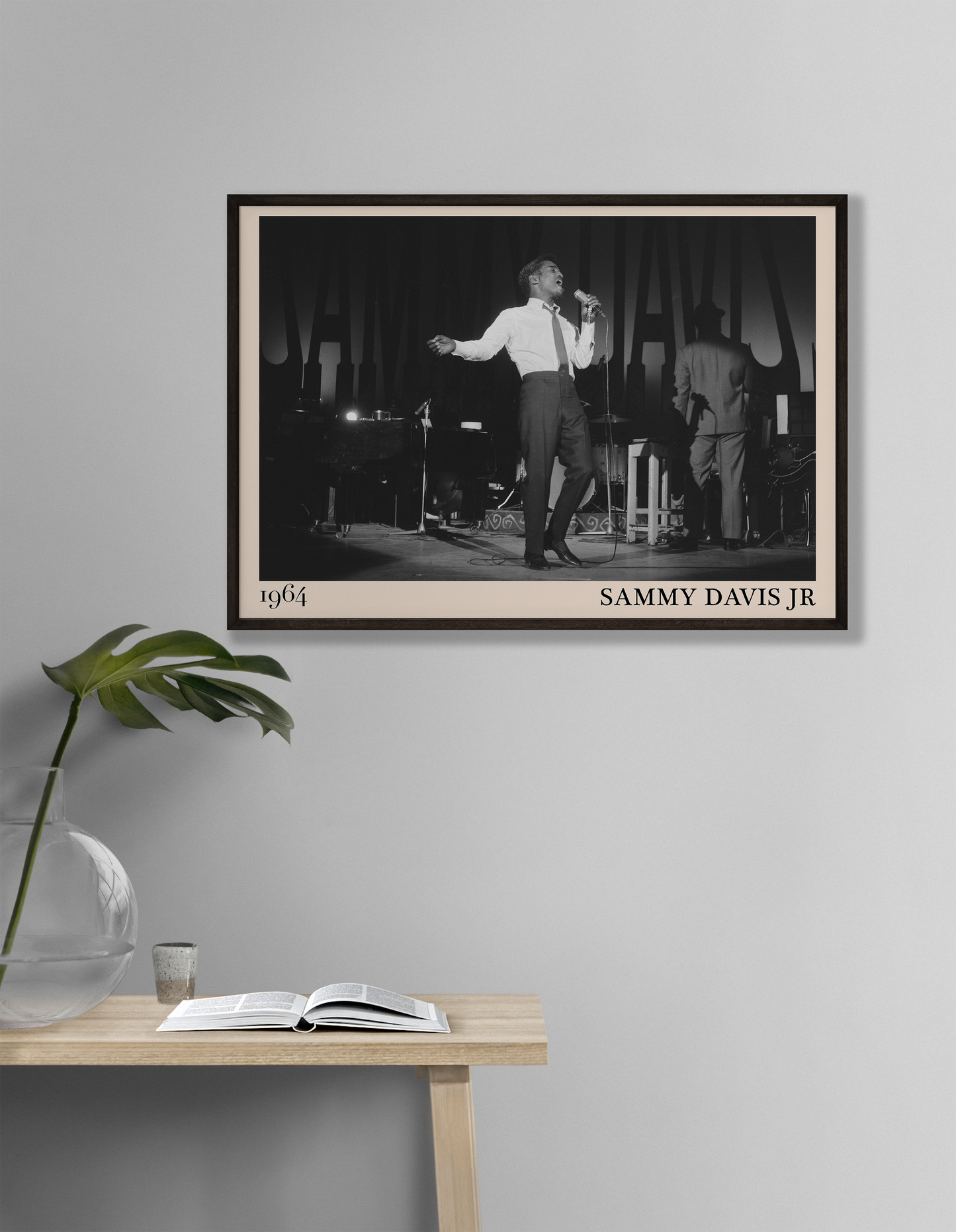 1964 picture of Sammy Davis Jr singing. Picture crafted into a cool black framed jazz print, with an off-white border. Poster is hanging on a grey living room wall