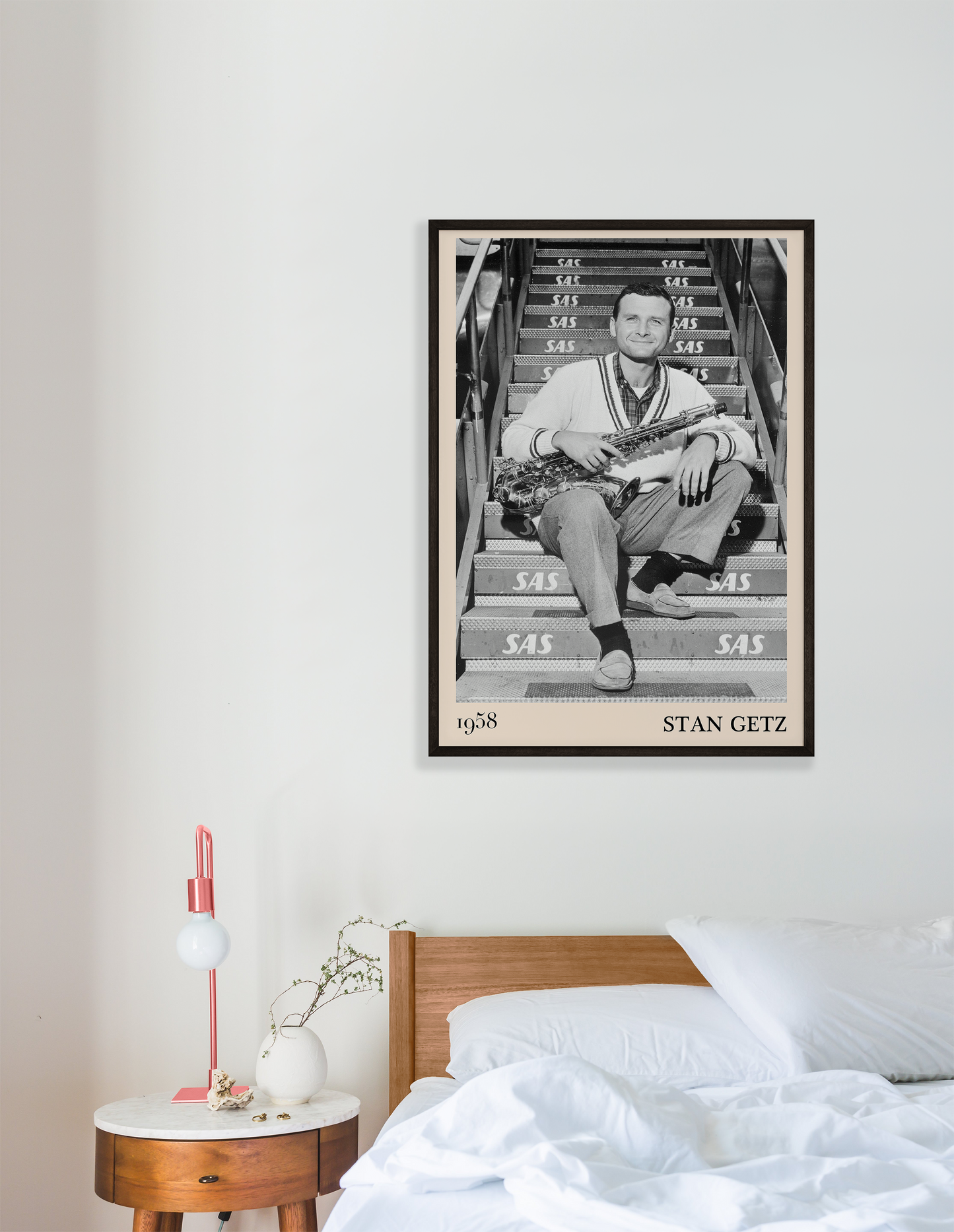 1958 picture of Stan Getz holding his saxophone. Picture crafted into a cool black framed jazz print, with an off-white border. Poster is hanging on a grey bedroom wall