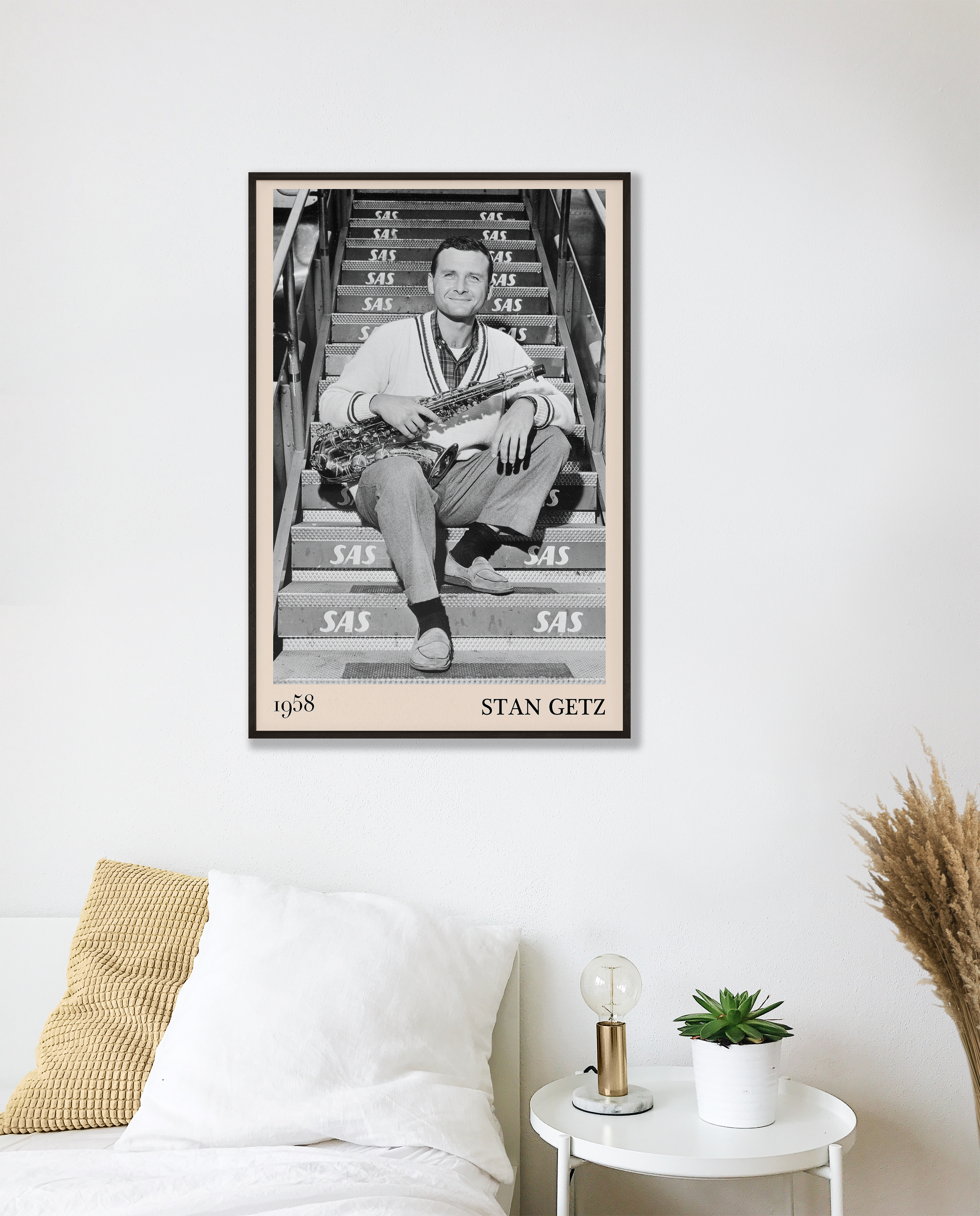 1958 picture of Stan Getz holding his saxophone. Picture crafted into a cool black framed music poster, with an off-white border. Poster is hanging on a white bedroom wall