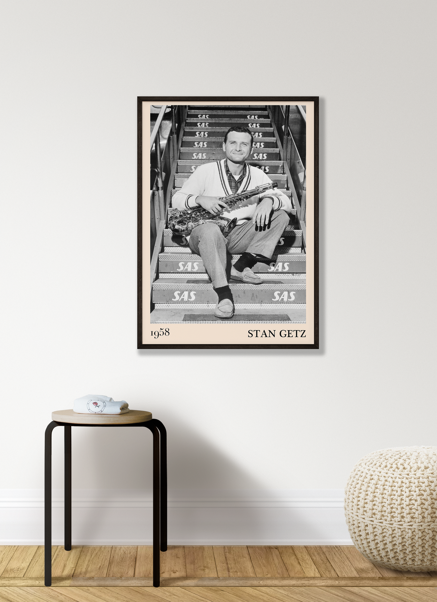 1958 picture of Stan Getz holding his saxophone. Picture crafted into a retro black framed jazz print, with an off-white border. Poster is hanging on a grey living wall