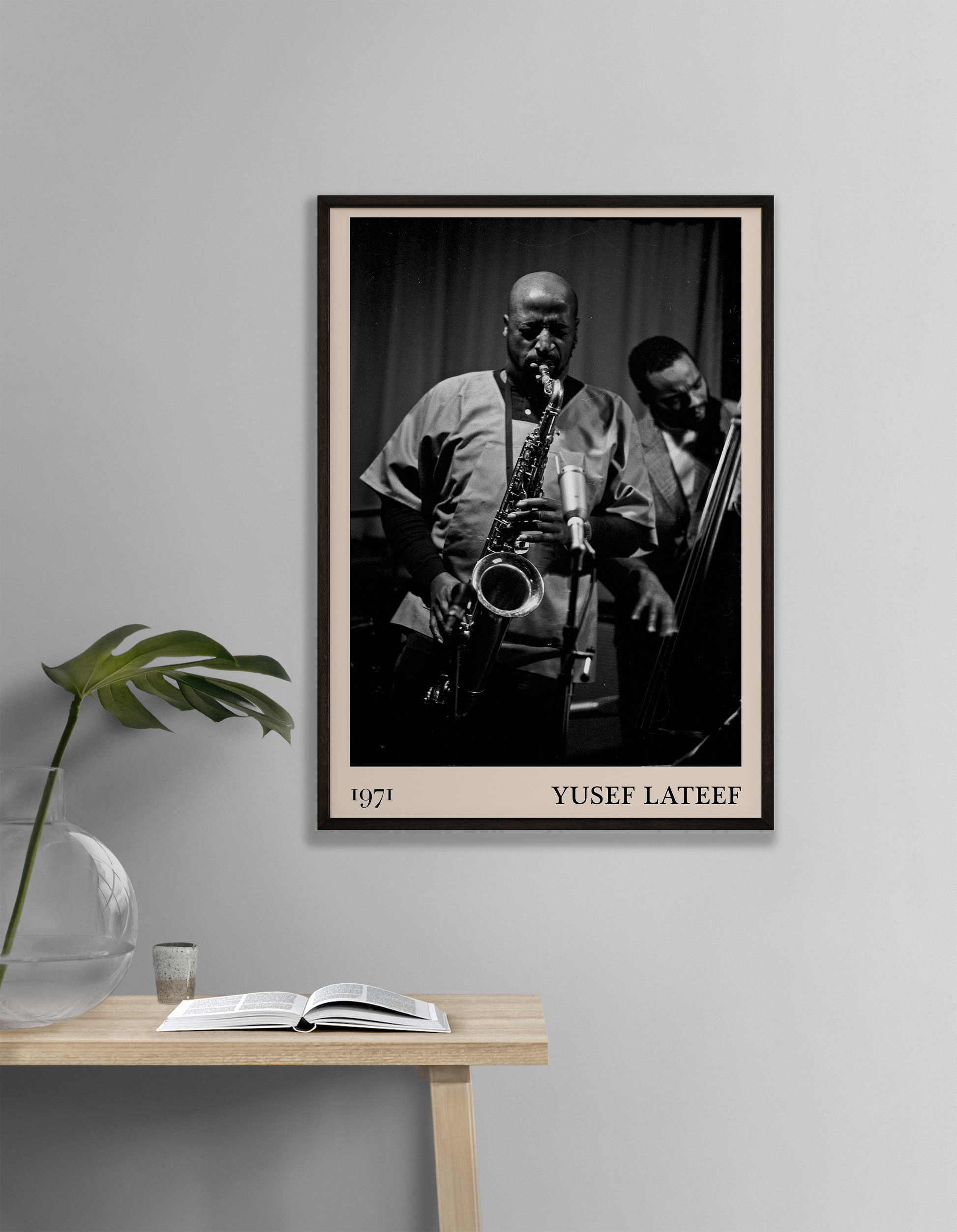 1971 photo of Yusef Lateef crafted into a black framed-poster, hanging on a white living room wall