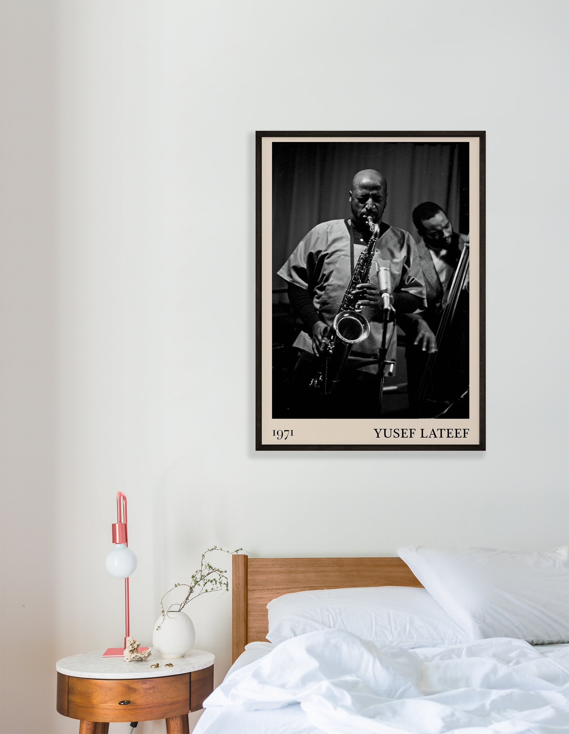 1971 photo of Yusef Lateef crafted into a black framed-poster, hanging on a white bedroom wall