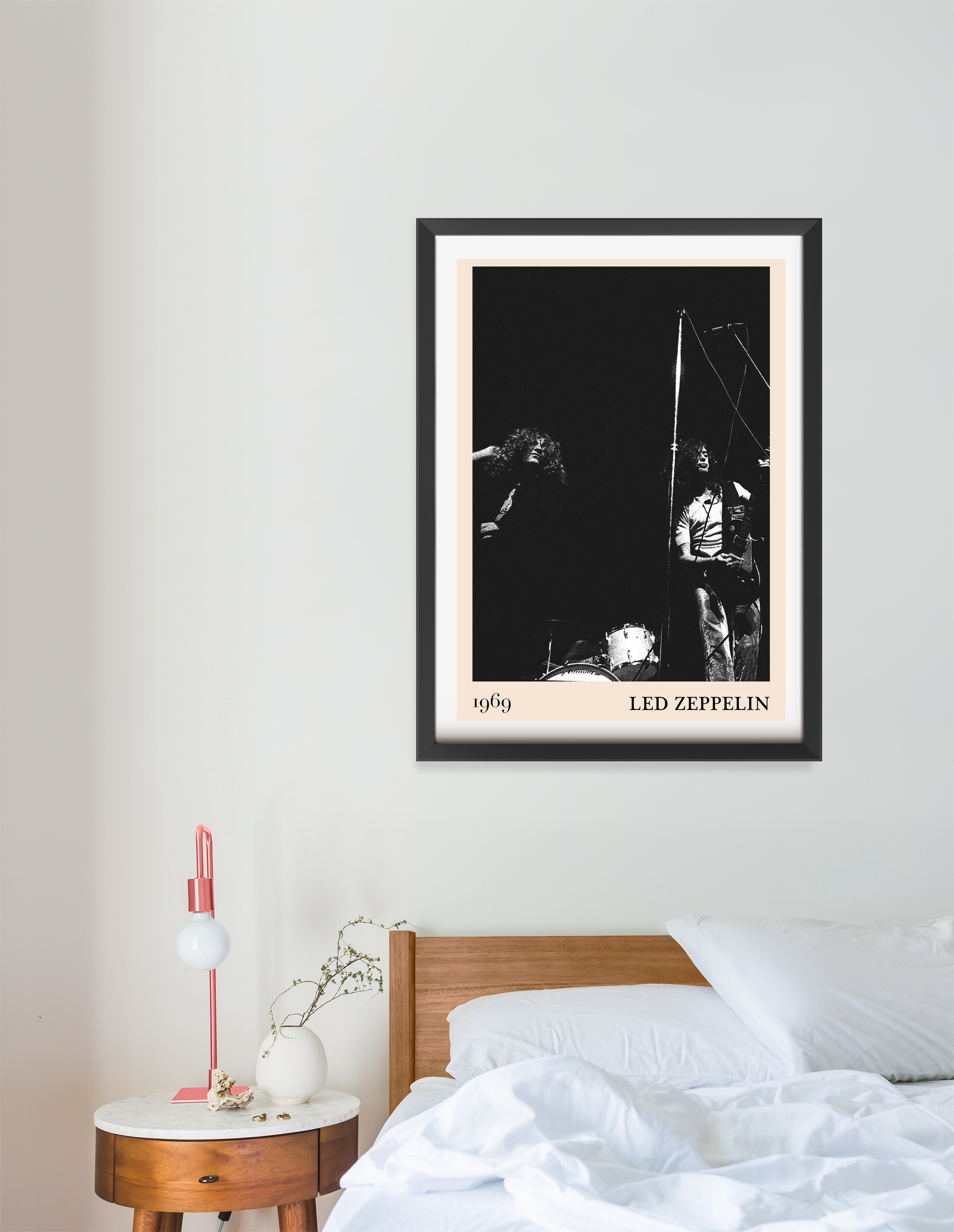 Led Zeppelin vintage rock poster in a black frame, portrait mount, above a modern bed with white bedding and wood headboard.