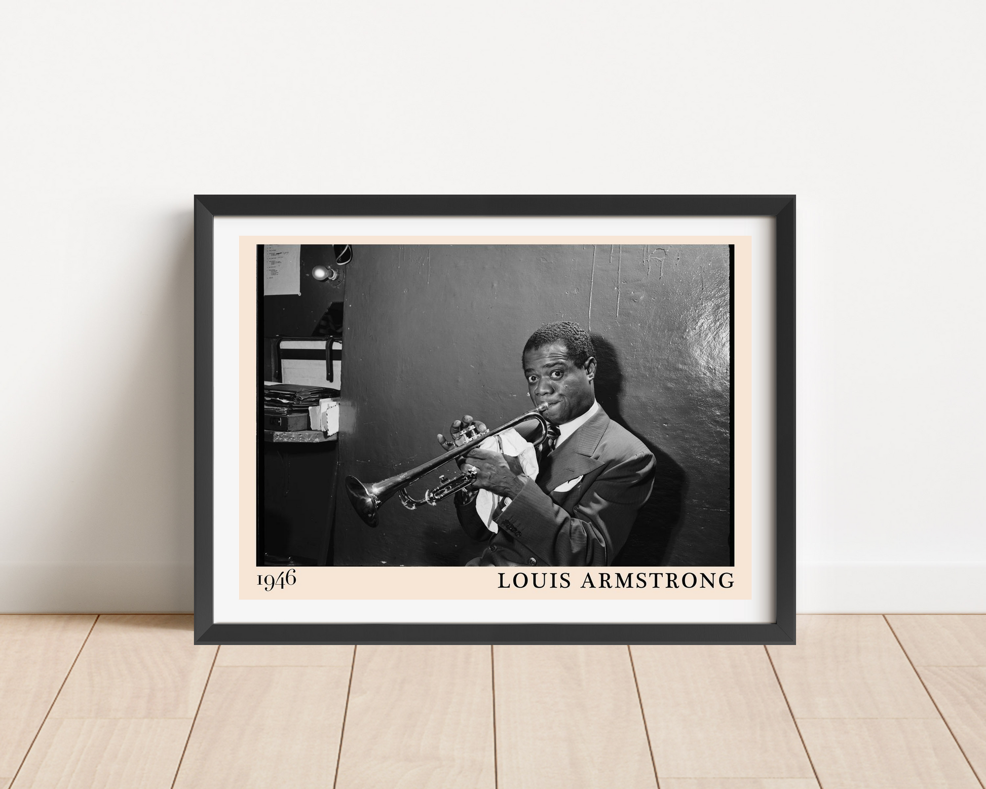 Louis Armstrong vintage jazz poster in black frame, landscape mount, on wooden floor against white wall, classic 1946 design