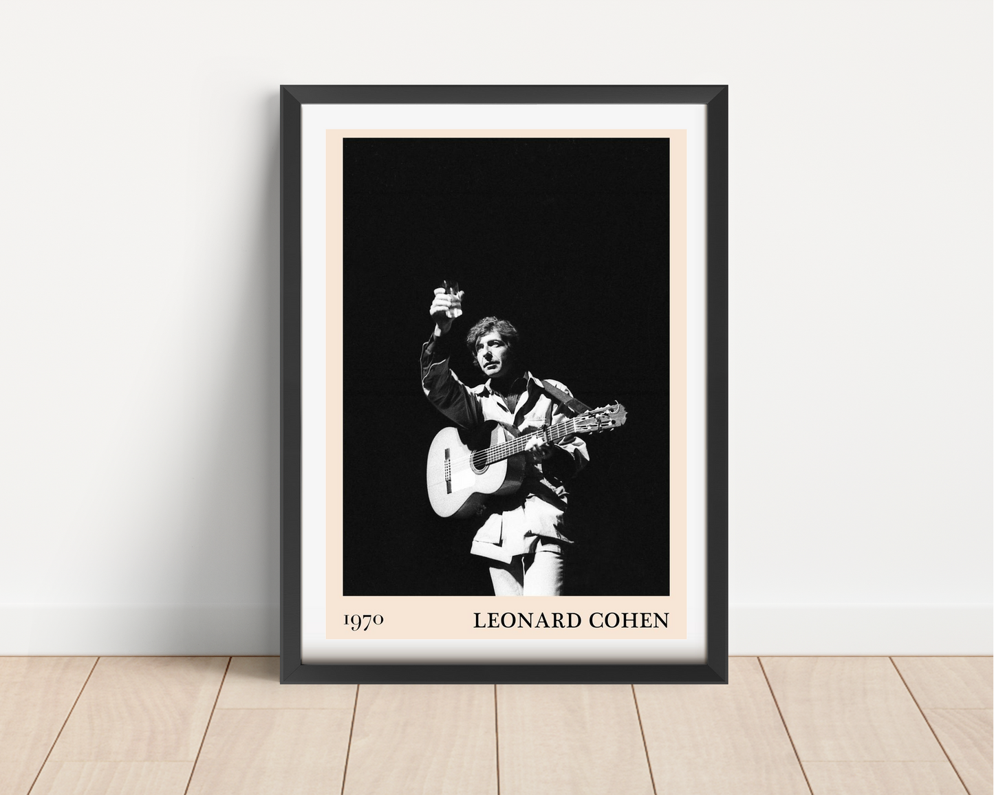 Leonard Cohen retro concert poster mockup in black frame, portrait mount, vintage black and white stage photo on wood floor.