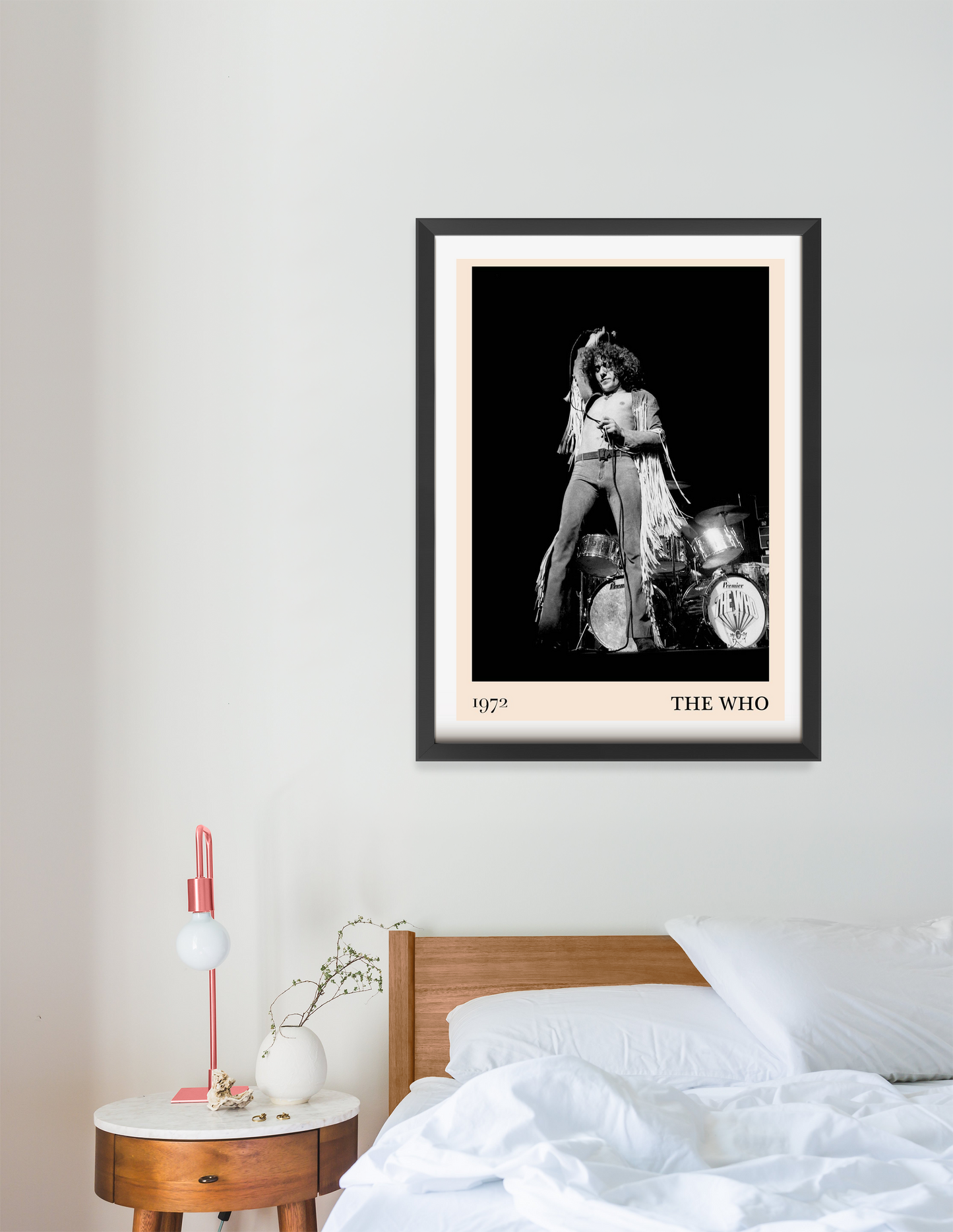 The Who vintage concert poster in a black frame, portrait mount, displayed above a modern wooden bed in a bright bedroom.