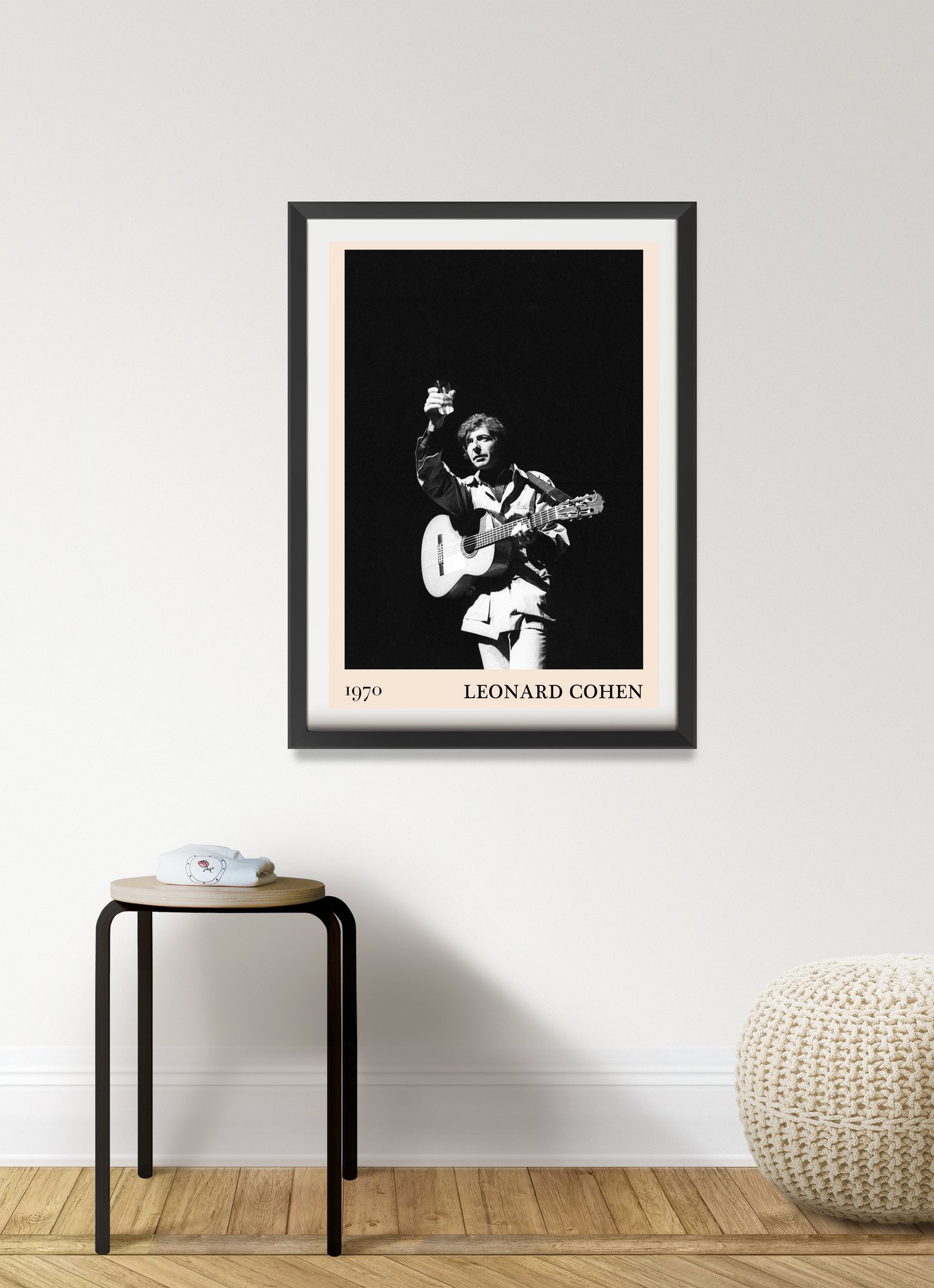Leonard Cohen Retro Concert Poster in portrait mount, black and white design framed on minimalist wall above wood stool.