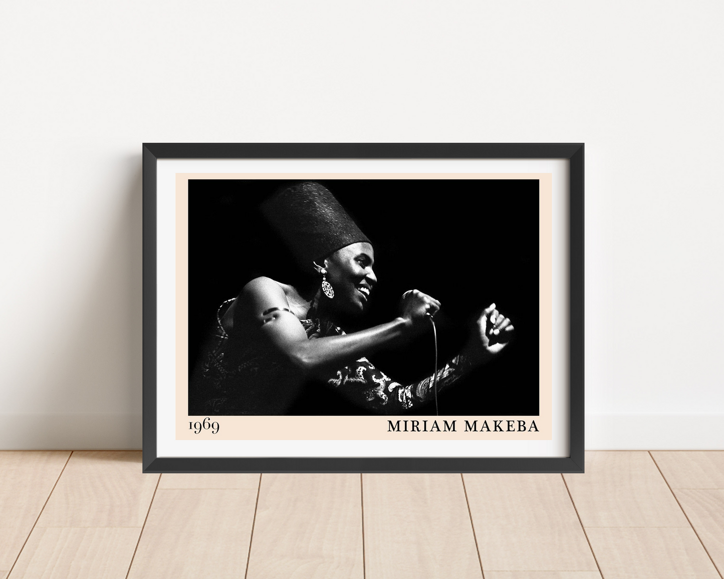 Miriam Makeba Jazz Concert Poster in landscape mockup, framed on wooden floor, features bold black and white portrait design.