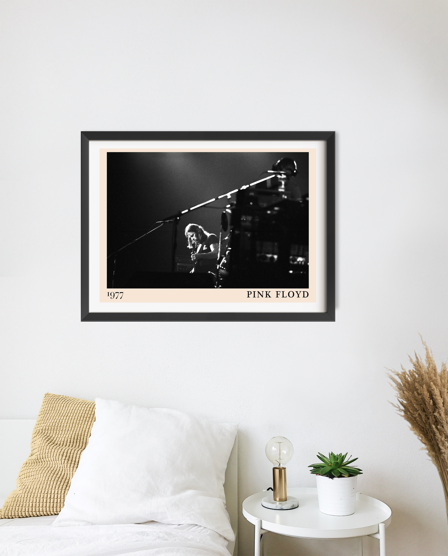 Pink Floyd rock concert poster in landscape 20 mount mockup, black and white stage photo above modern white bedroom décor.
