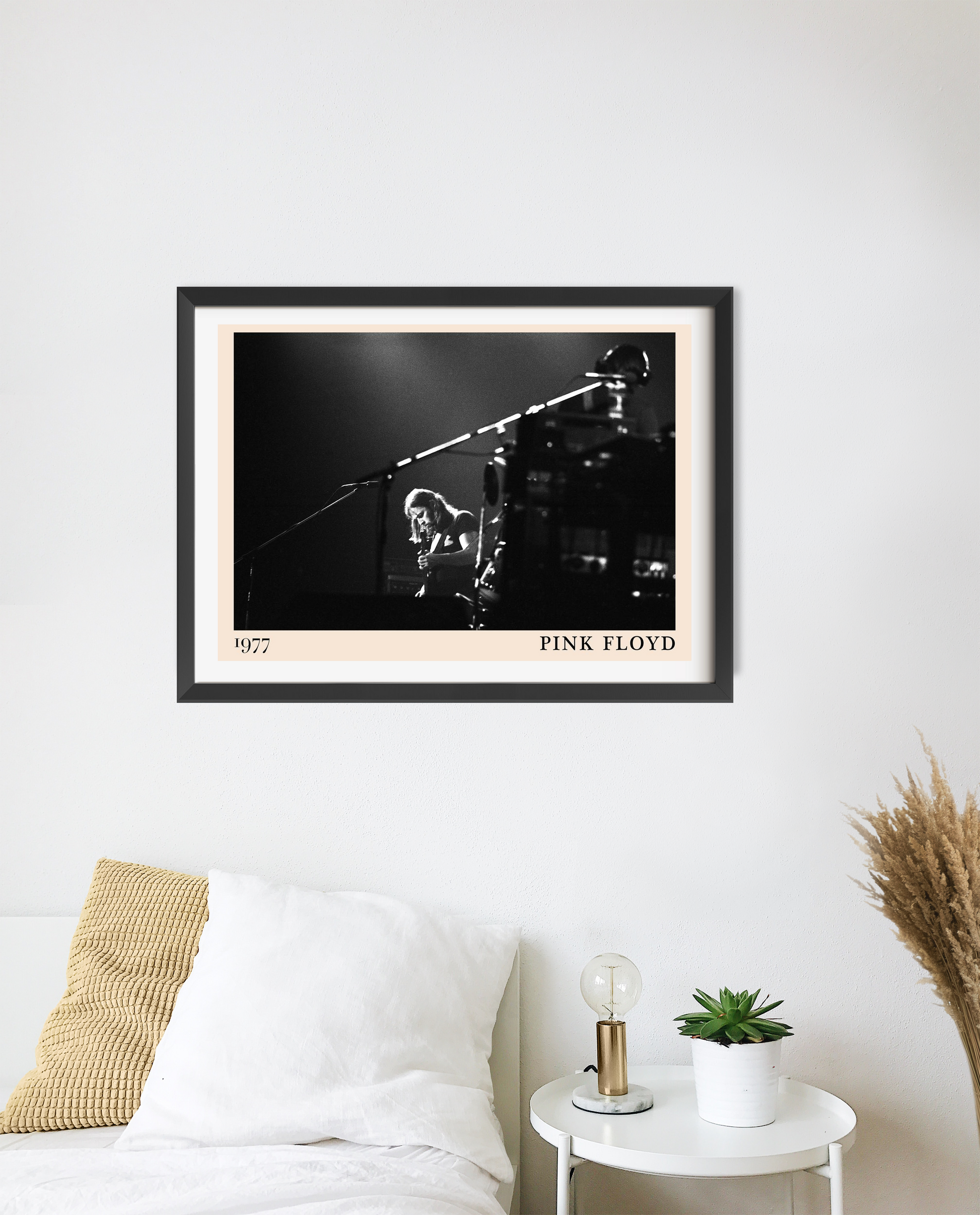 Pink Floyd rock concert poster in landscape 20 mount mockup, black and white stage photo above modern white bedroom décor.