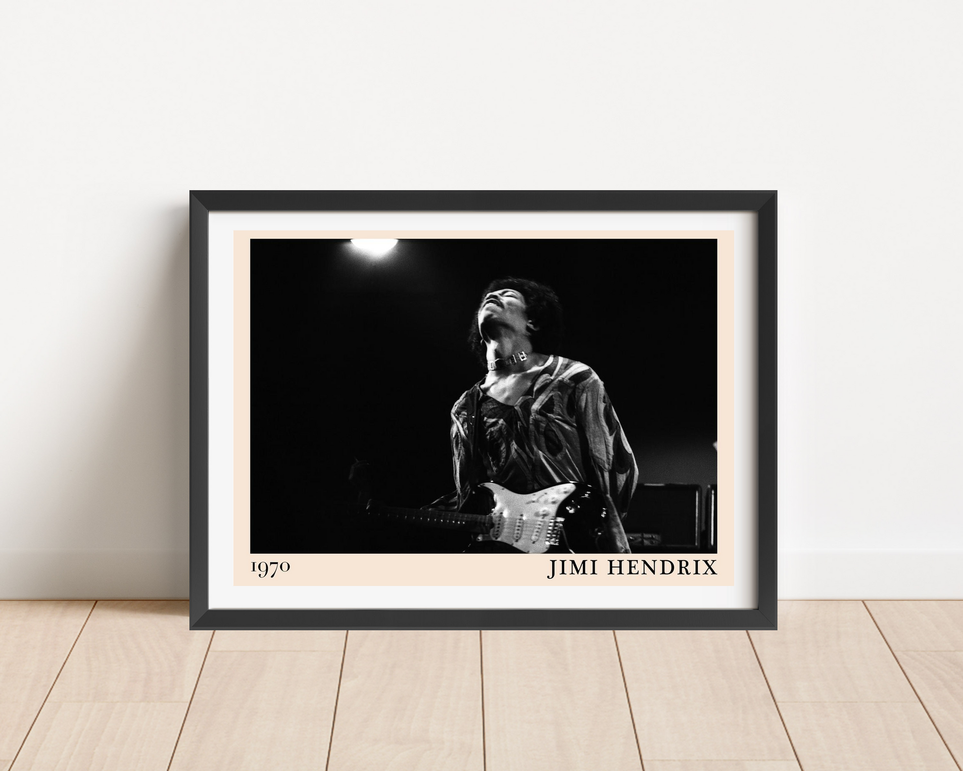 Jimi Hendrix vintage concert poster mockup in black frame, leaning on wooden floor, features bold monochrome stage photo desi