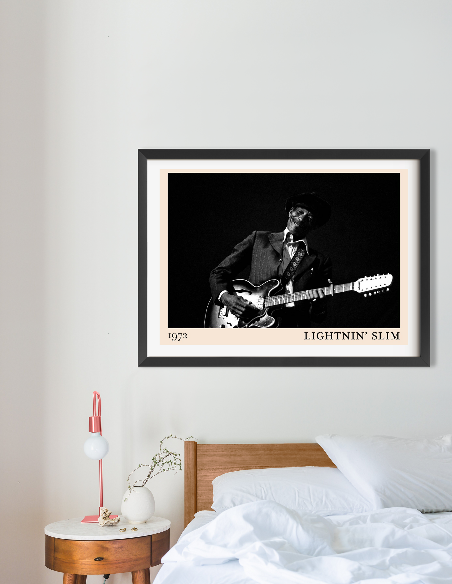 Lightnin Slim Blues Poster in landscape mount above modern bed, features black-and-white 1972 guitar portrait in sleek frame.