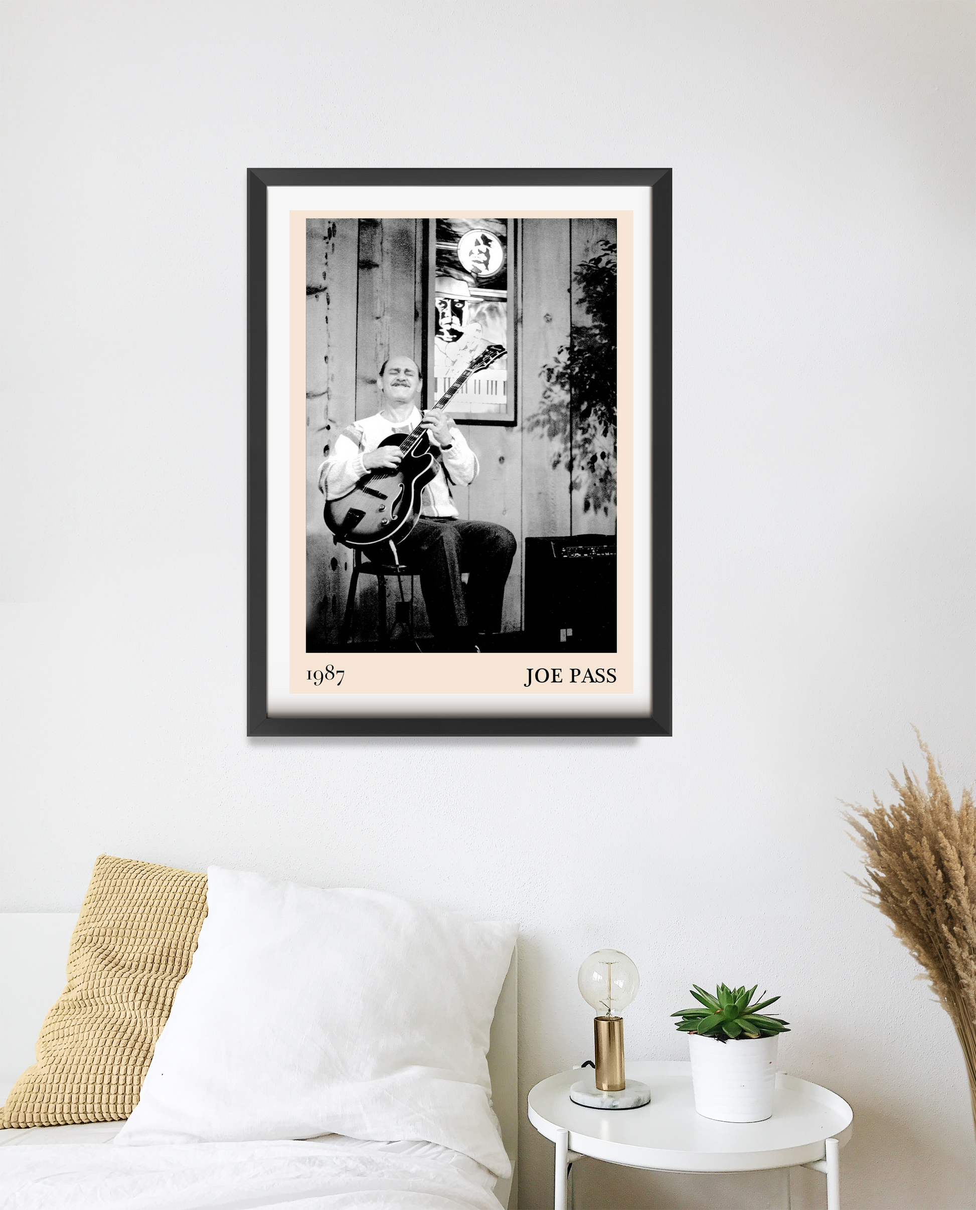 Joe Pass Retro Jazz Poster in black frame on bedroom wall, features vintage musician photo with beige border and bold text.