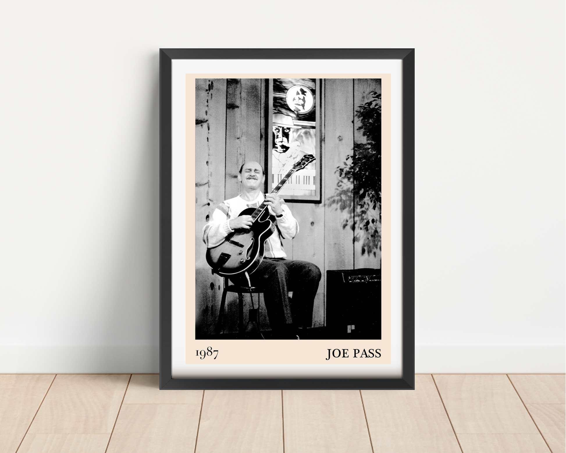Joe Pass Retro Jazz Poster in portrait main mount mockup, black frame, vintage jazz guitarist artwork on wooden wall.