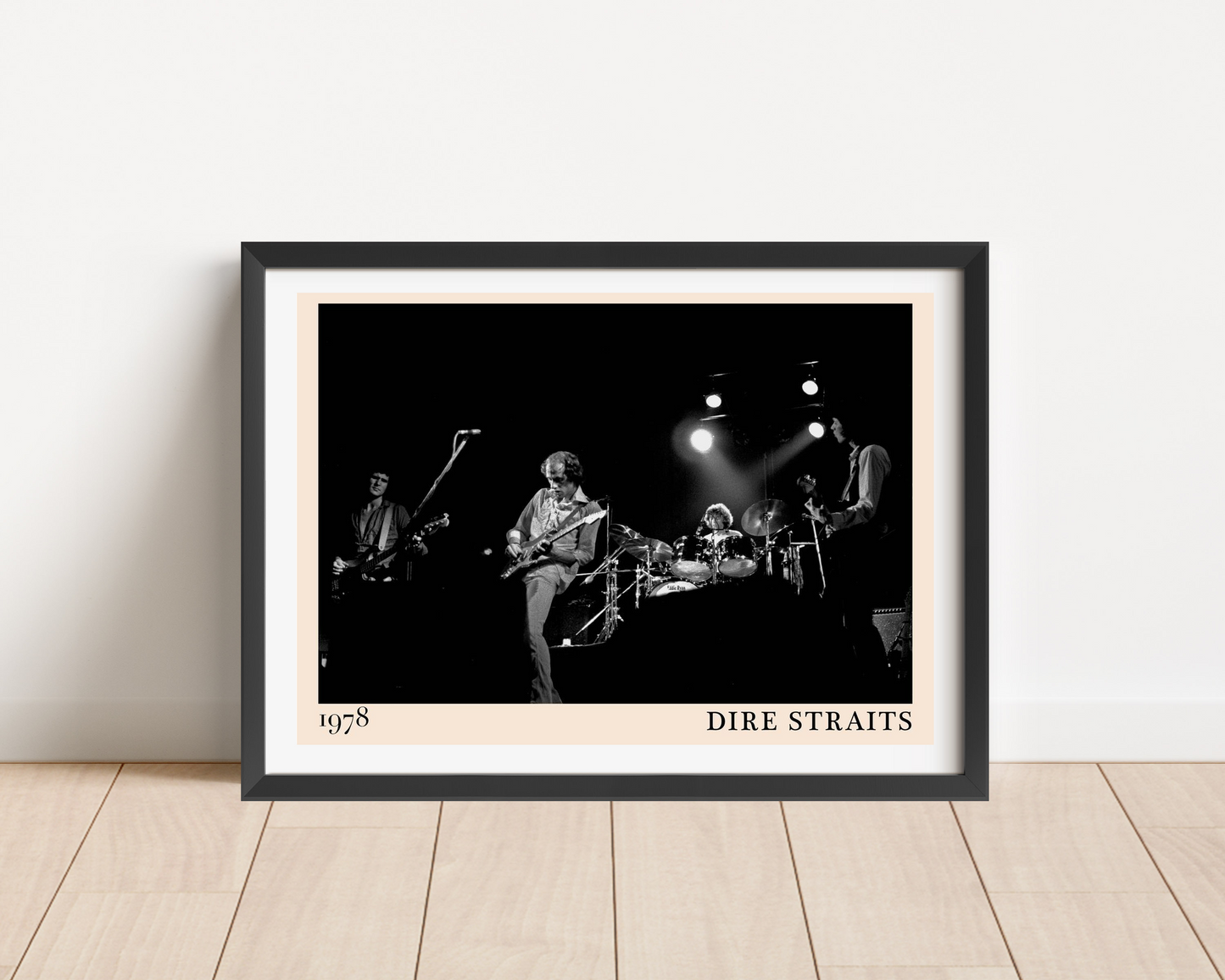 Dire Straits Retro Poster in landscape frame on wooden floor, features black and white 1978 band photo with bold text border.