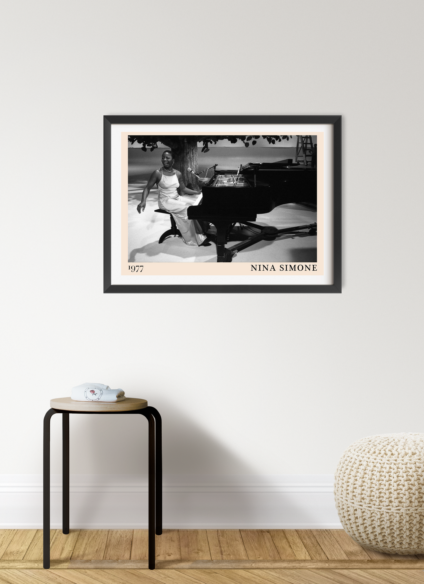 Nina Simone vintage poster in black frame on white wall, features black-and-white piano scene, styled in modern living room.