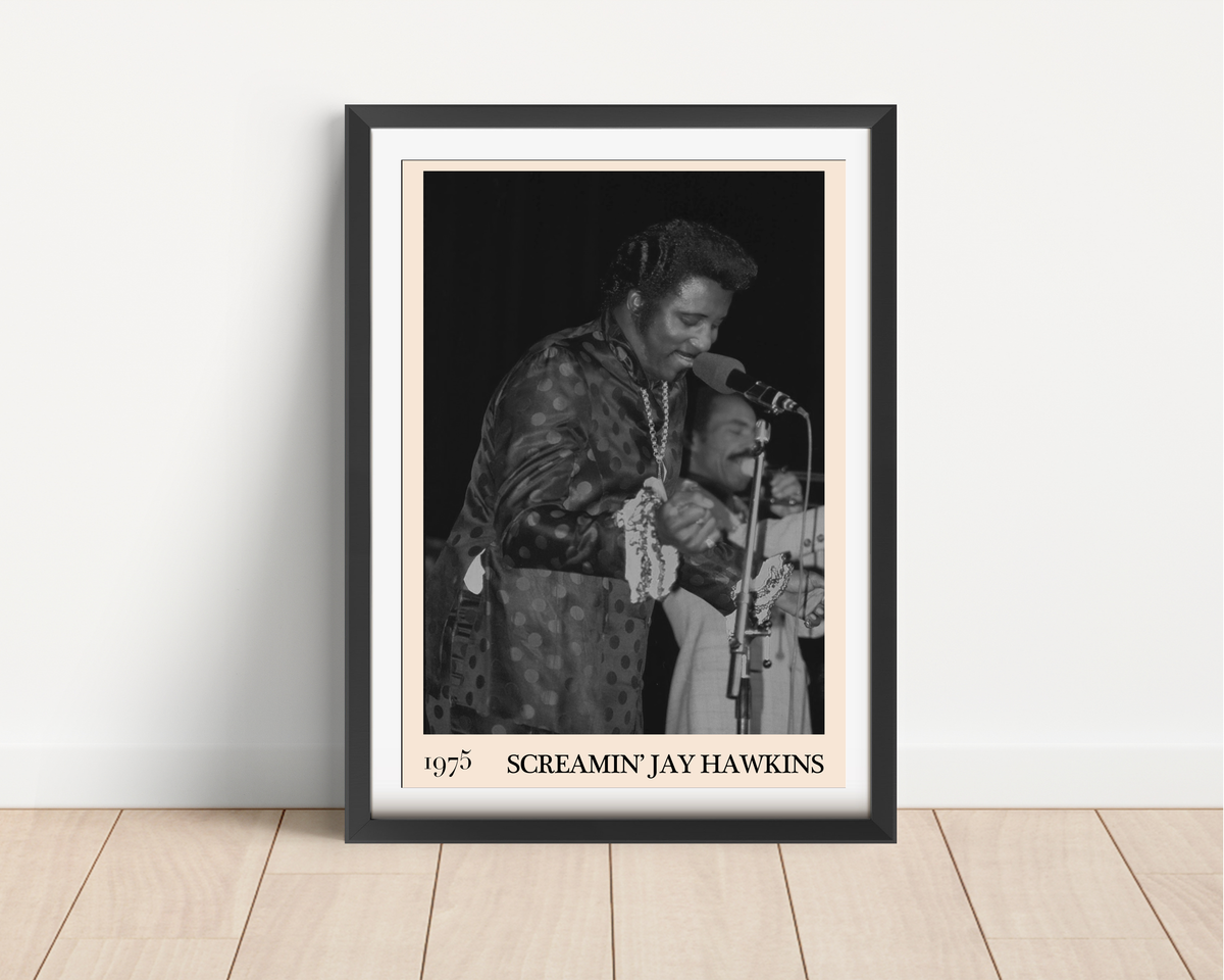 Framed print of Screamin Jay Hawkins performing live in 1975, black and white photo, leaning against a white wall on light