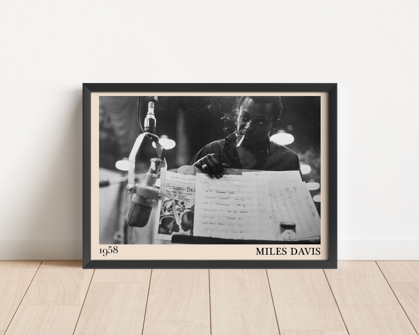 Miles Davis Jazz Print. Crafted into a black frame and leaning on a white wall.